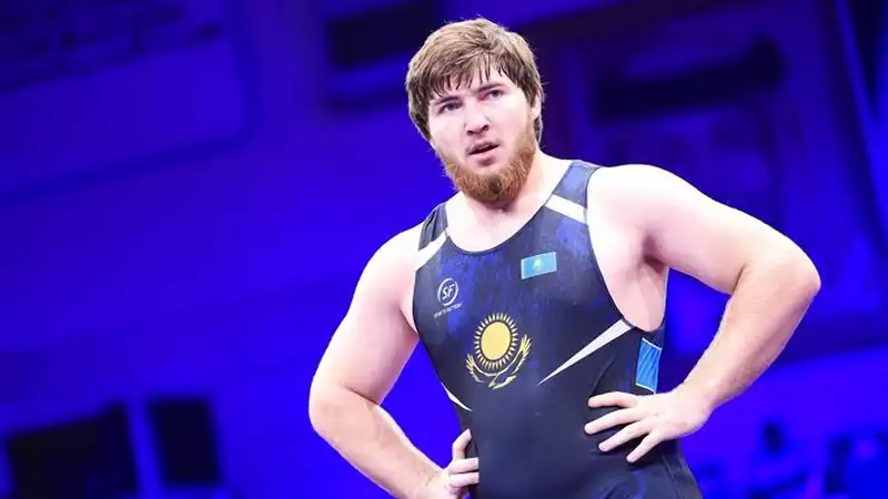 Казахстанский борец Джохар Узаров на ковре стоит 