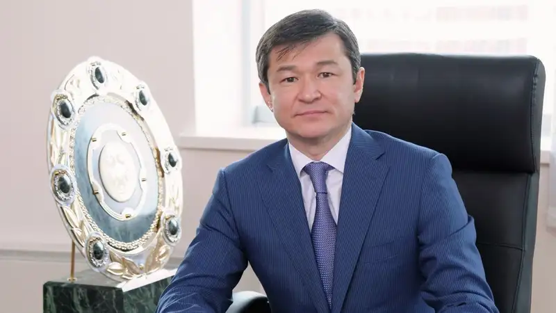 Руководитель "Астаны" Саян Хамитжанов на фоне тарелки чемпиона  